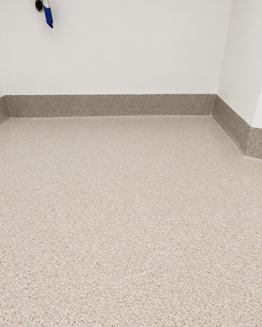 Close view of a speckled bathroom floor and coved base for the Vancouver Island Health Authority
